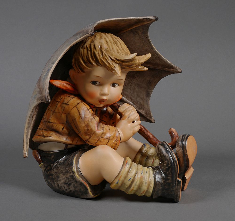 hummel boy walking with umbrella